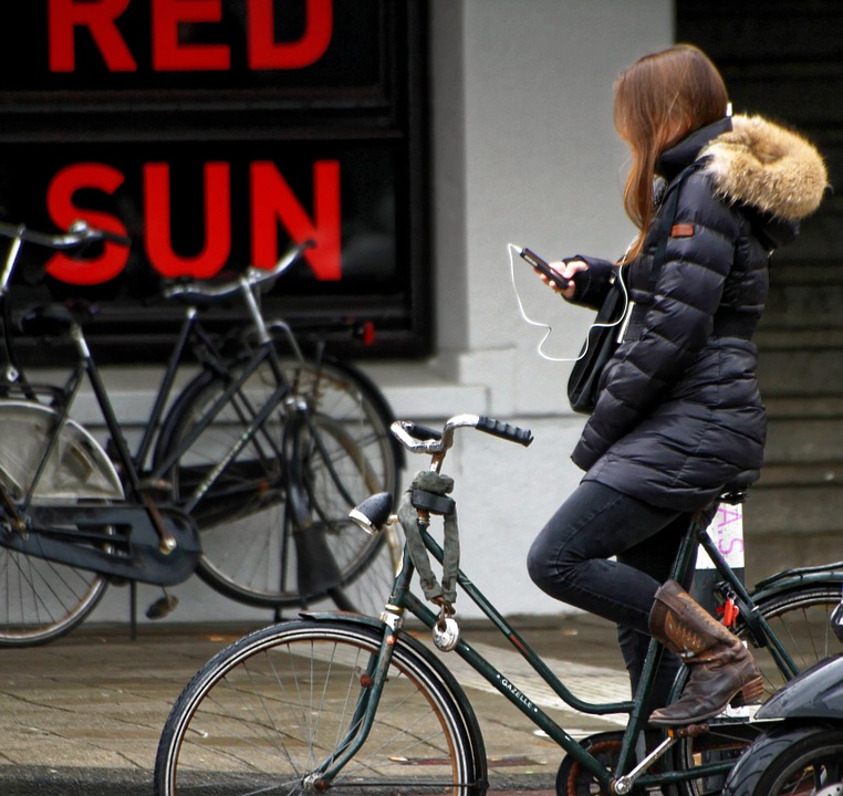 Girl on bike listending to iPhone read to her