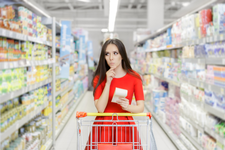 Woman in grocery store, contemplating which groceries to buy
