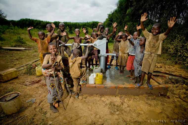 Rwandan children celebrating around charity: water well