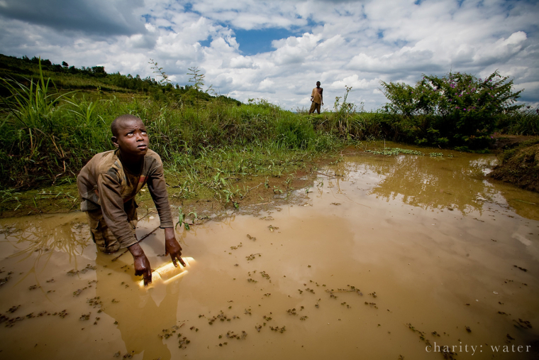 Rwandan collecting filthy water