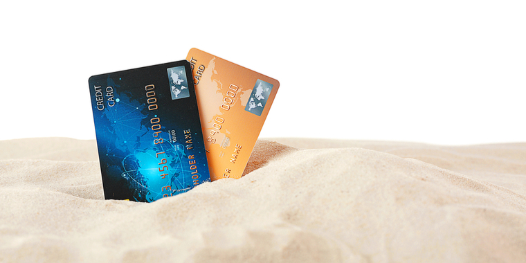 2 credit cards stuck in the sand