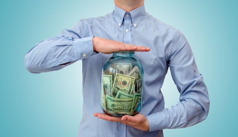 Man holding glass jar with money in it